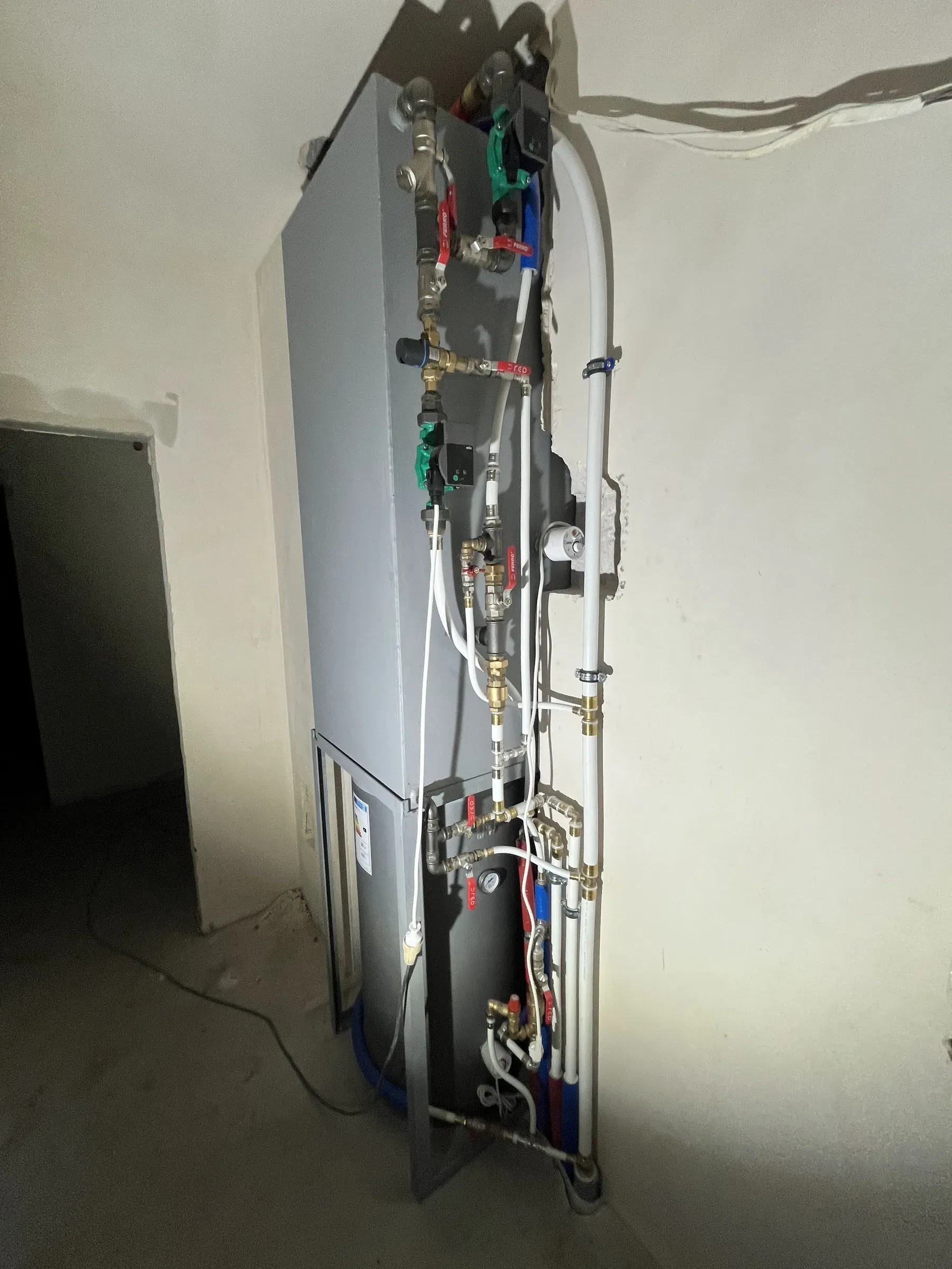 Zasobnik z pompami obiegowymi i armaturą w pomieszczeniu technicznym